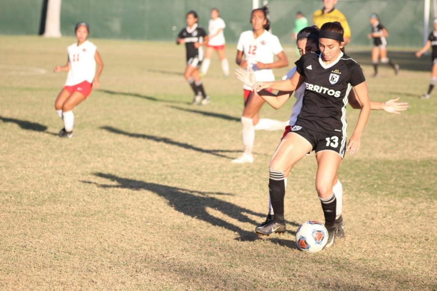 No.+13+Stephanie+Nava%2C+freshman--midfielder%2C+guides+the+ball+as+she+is+hounded+by+a+defender.+Falcons+won+game+against+Chaffey+College+2-1%2C+in+a+Nov.+21+playoff+game.+Photo+credit%3A+Jah-Tosh+Baruti