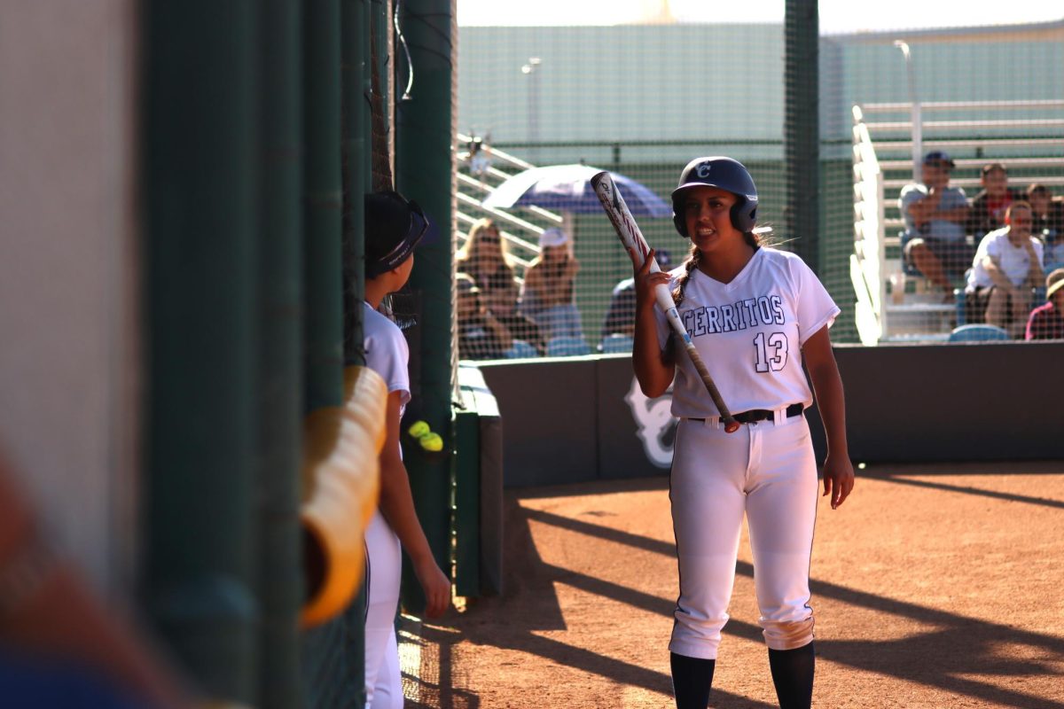 Nadia Landeros talking with her teammates outside of the dugout.