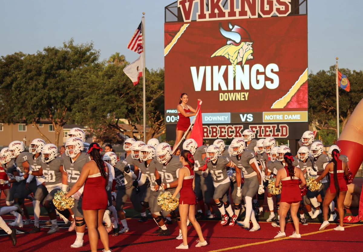 Downey High School football players running out of the tunnel.