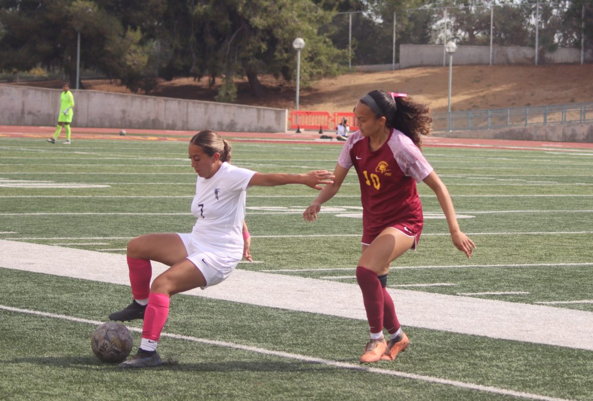 #7 Rubi Vazquez holding back defender #10 Sydney Esquival. 