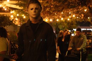 Roman Ikram dressed as Michael Myers, walking along the market. 