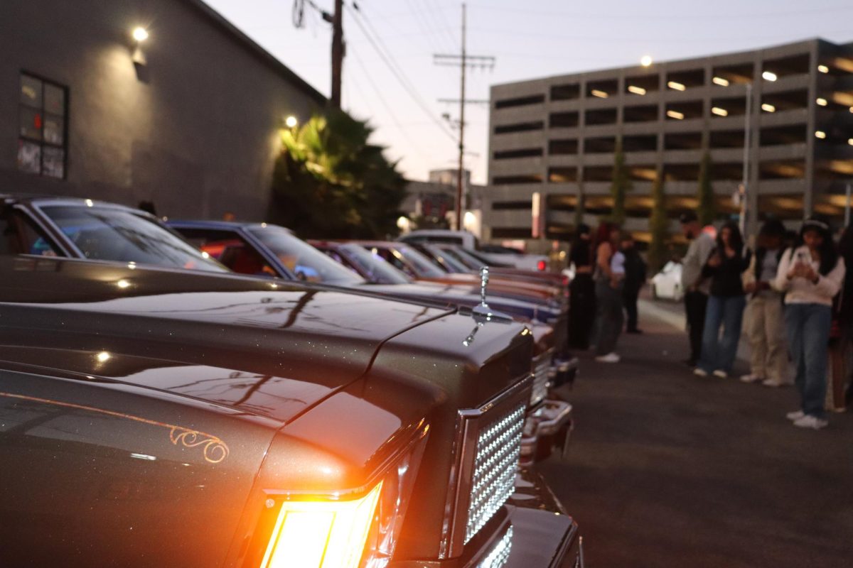 People taking pictures with the lowriders at the Por Vida event on Sept. 28. Photo credit: Alejandra Guerra