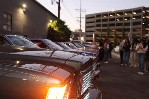 People taking pictures with the lowriders at the Por Vida event on Sept. 28. 