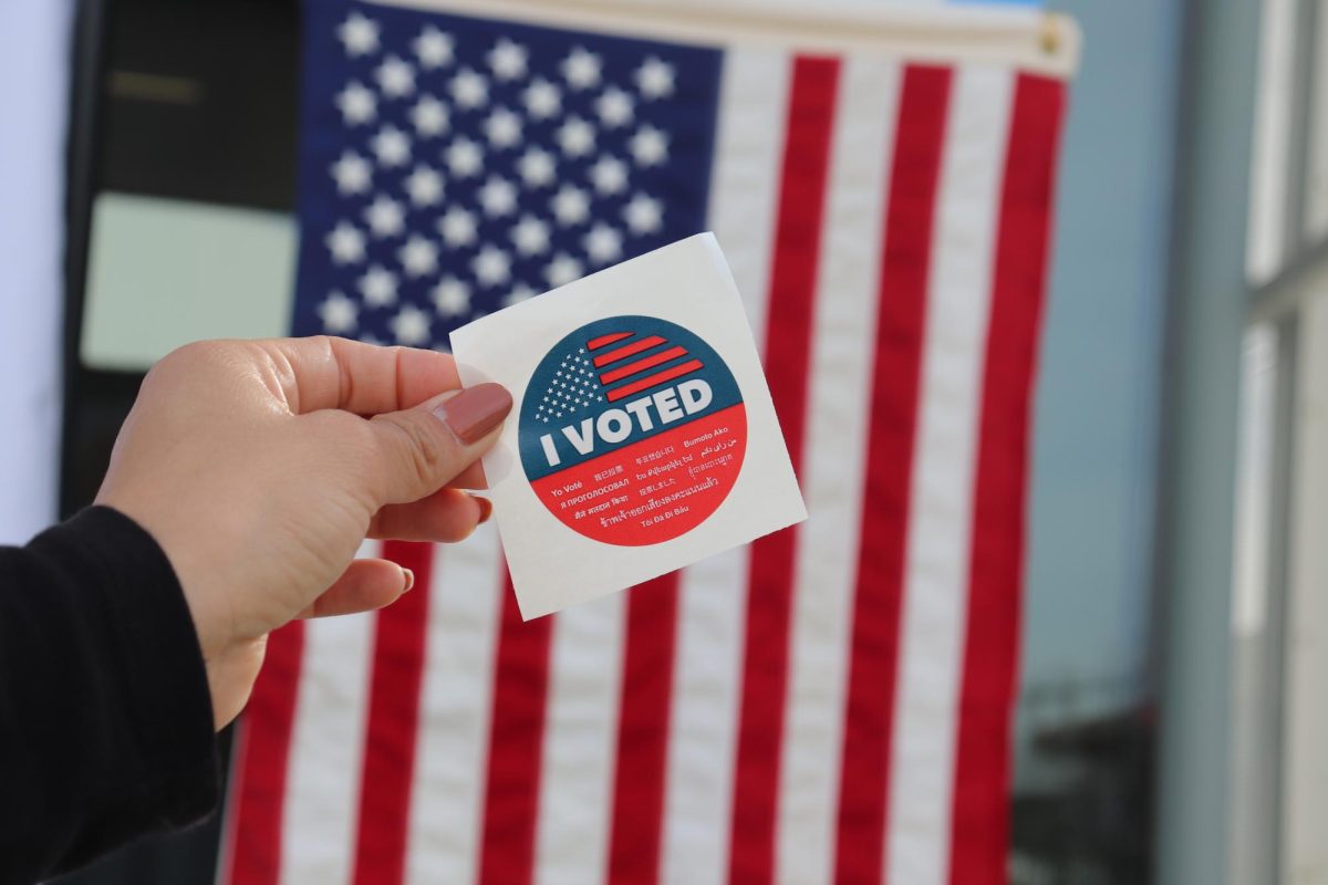 An "I Voted" sticker in front of the American flag. Photo credit: Laura Bernal