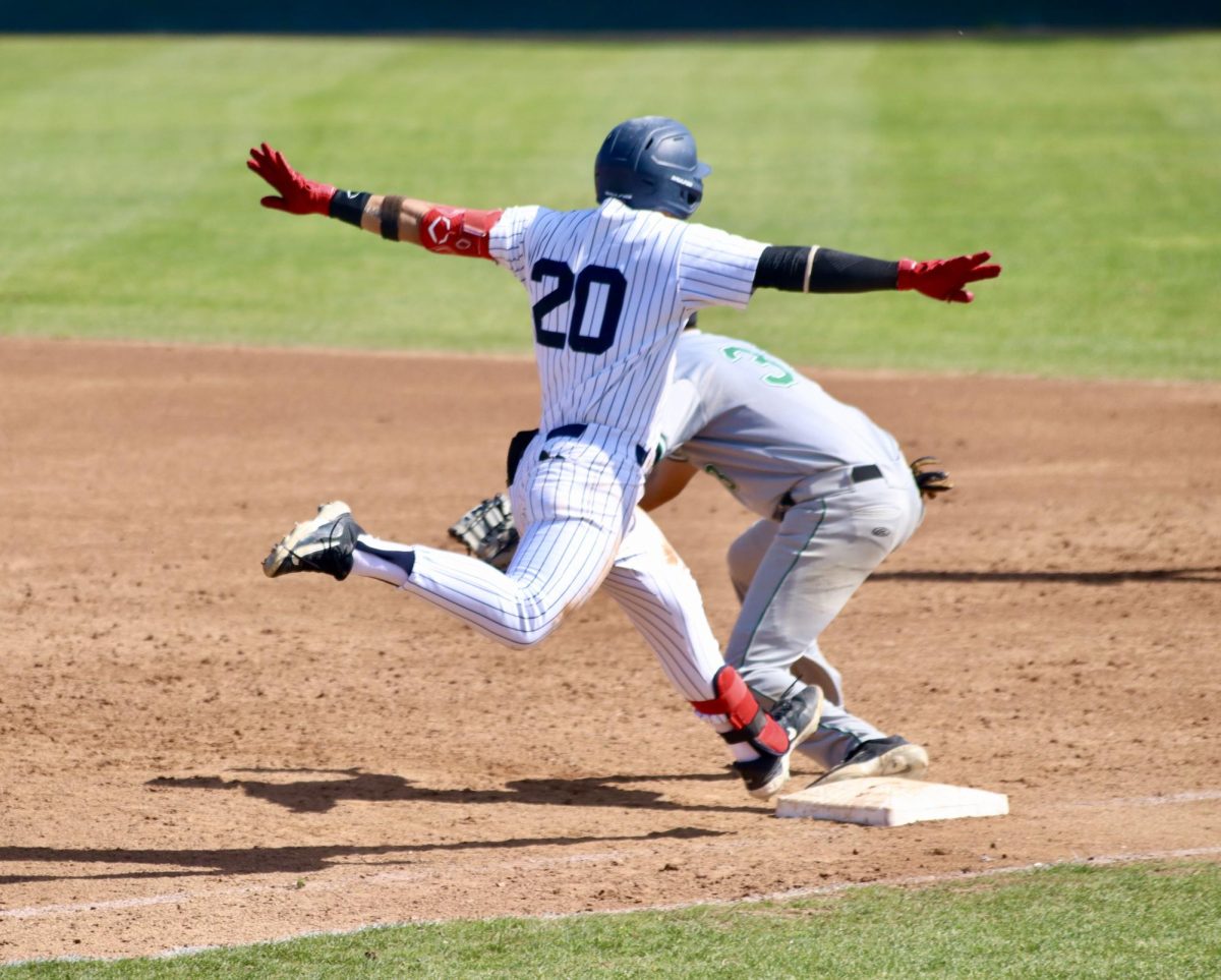 Infielder, Anthony Bassett signaling the safe sign as he makes it into first base safely March 21, 2024 