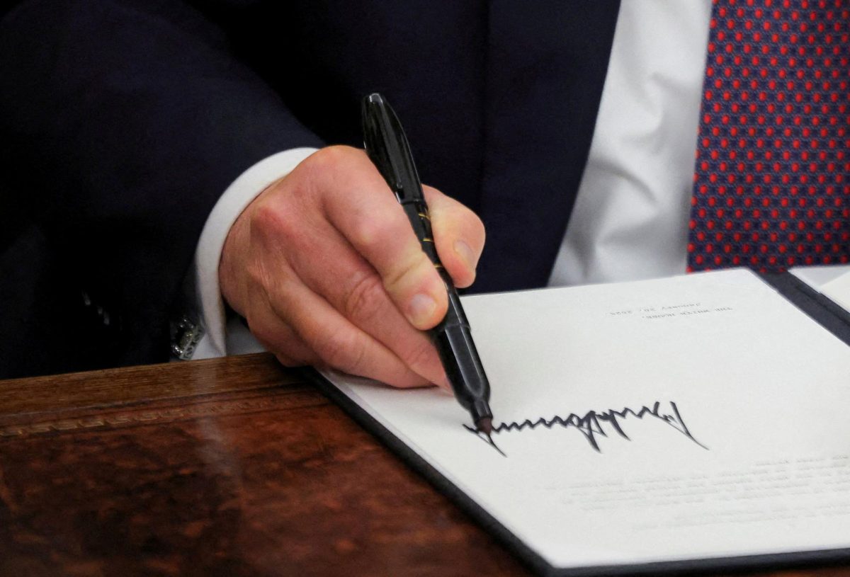 U.S. President Donald Trump signs documents as he issues executive orders in the Oval Office at the White House on Inauguration Day in Washington, U.S., January 20, 2025.  REUTERS/Carlos Barria