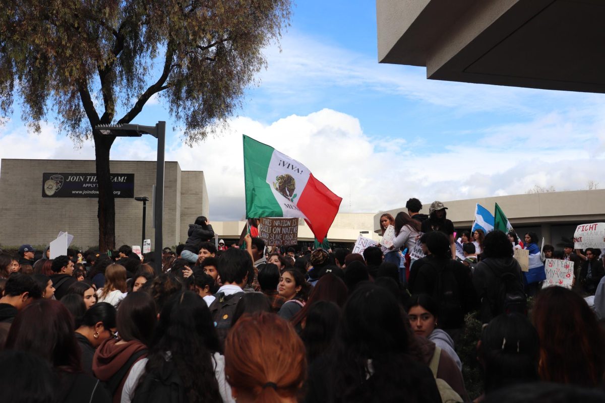 Downey and Warren high school students in front of Downey City Hall with the Mexican flag waving in the middle of the crowd on Feb. 6, 2025.