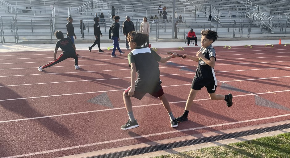 Bellflower Intramural runner Bryan takes the baton from his teammate in 4x400 meter race during the hand off on Feb. 3, 2025.