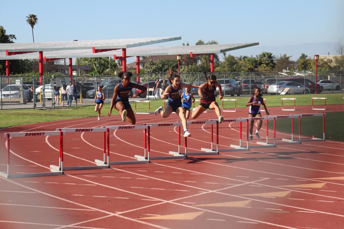Warren athletes race to hold off Downey during the Varsity Women's 300 meter hurdles at the Suburban Valley Conference championship event on April 9, 2025.