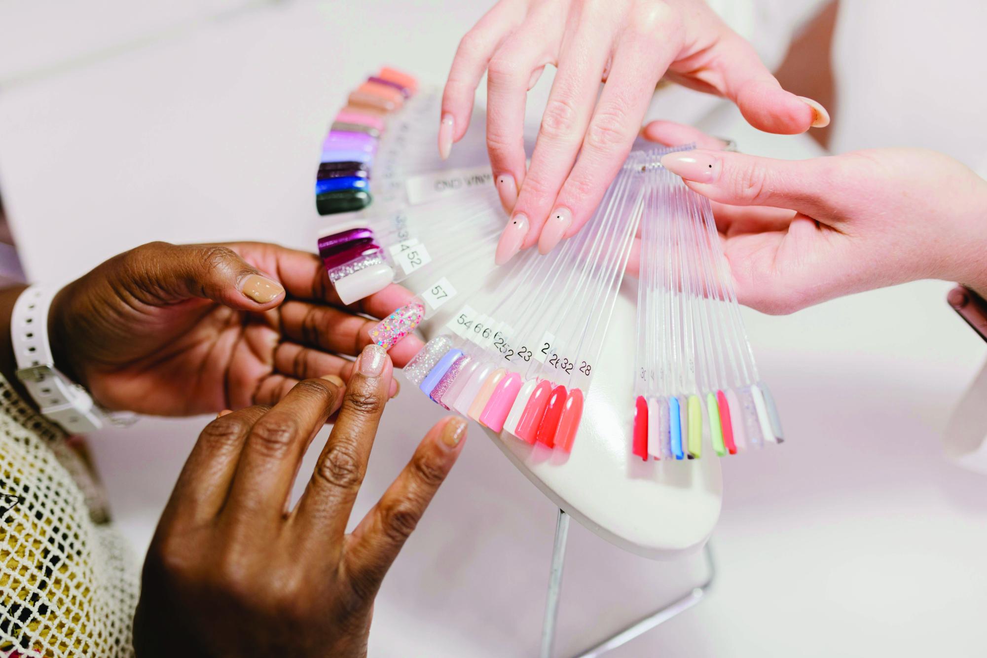 A Client Choosing on a Nail Color Palette. Photo credit: pexels